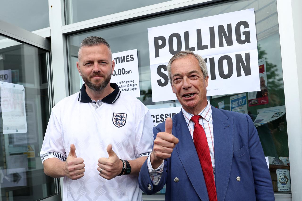 Reform UK's candidate Rob Kenyon and Reform UK Leader Nigel Farage pose for a photo at a polling station in Winstanley, in north-west England, June 18, 2026. (AFP Photo)