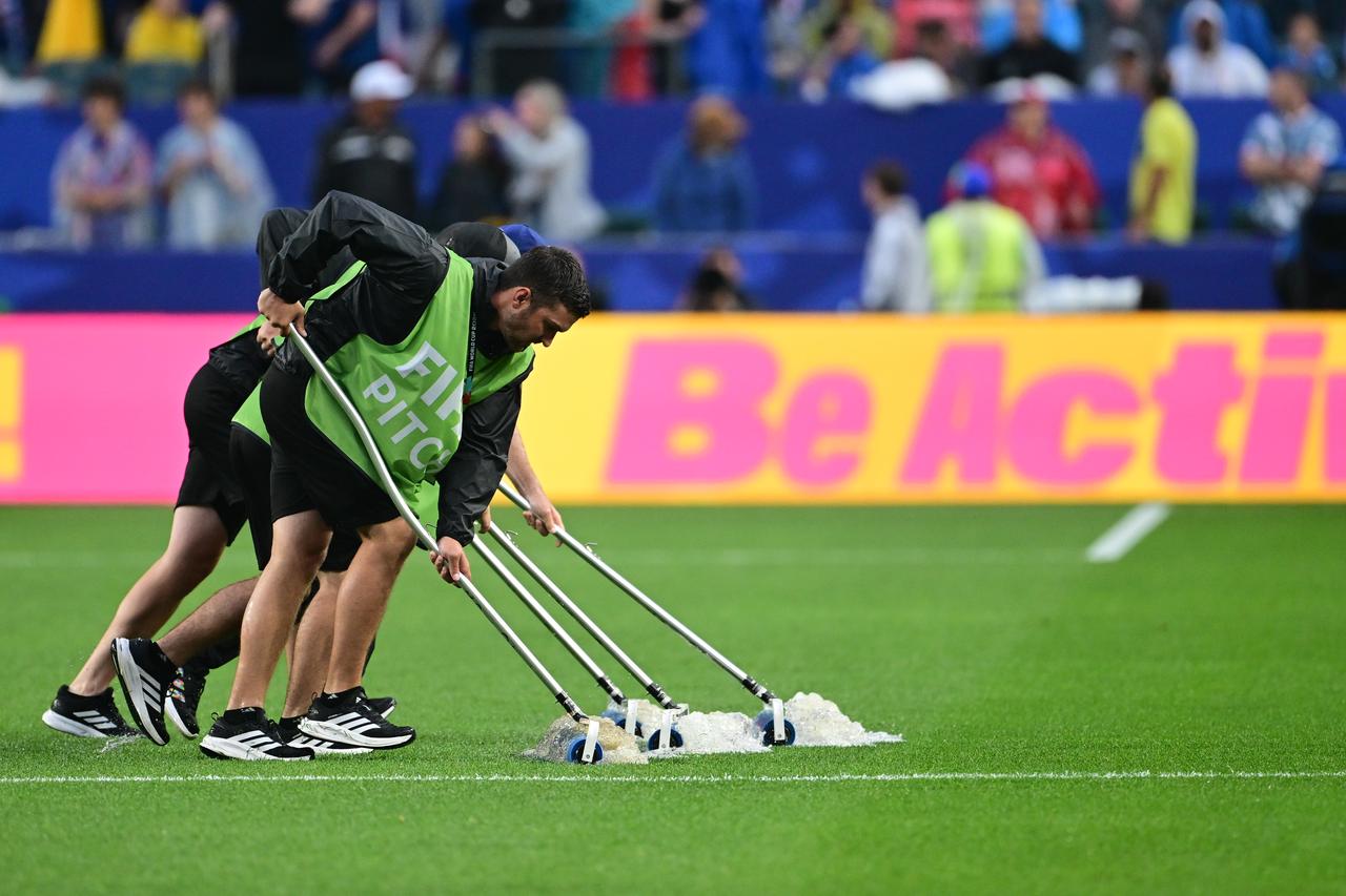 Ground staff clear water from the pitch after heavy rain delayed the second half of the FIFA 2026 World Cup Group I match between France and Iraq at Philadelphia Stadium in Philadelphia, U.S., June 22, 2026. (AA Photo)