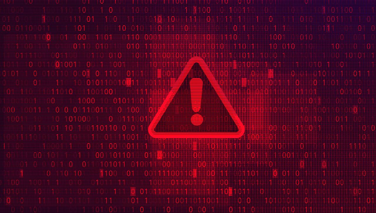 A digital warning symbol appears over binary code. (Adobe Stock Photo)