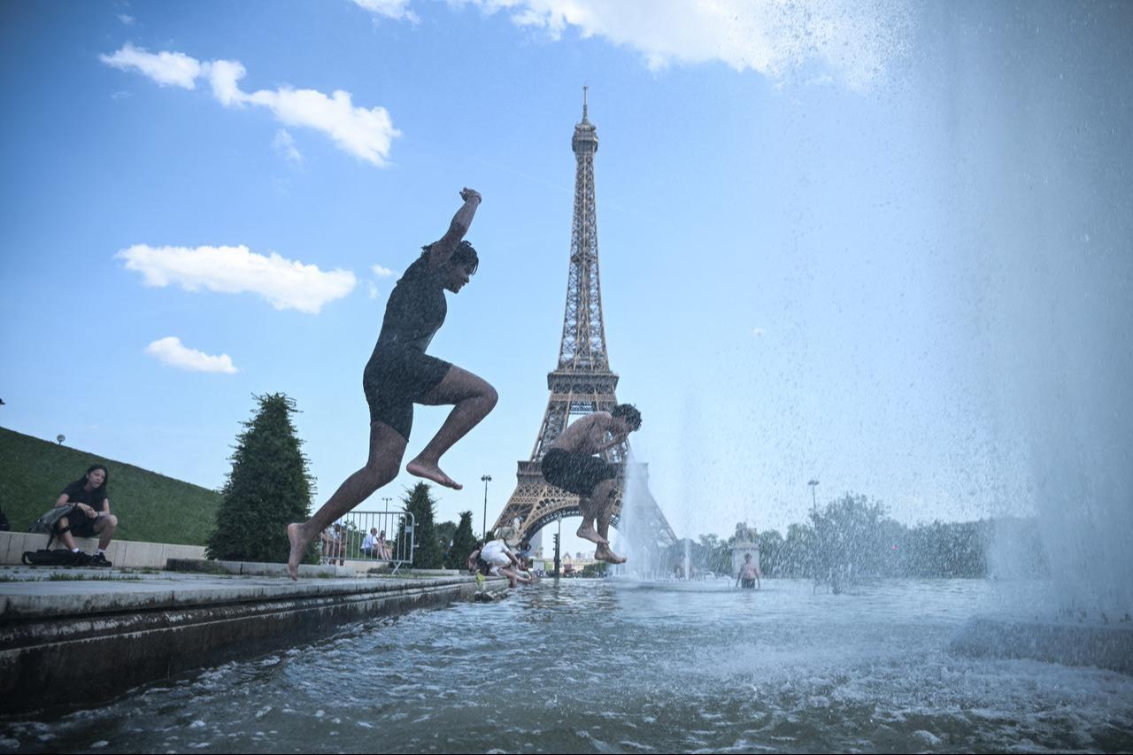 People jump in the Trocadero Fountain near the Eiffel Tower during a heatwave in Paris, France, on June 22, 2026 (AFP Photo)
