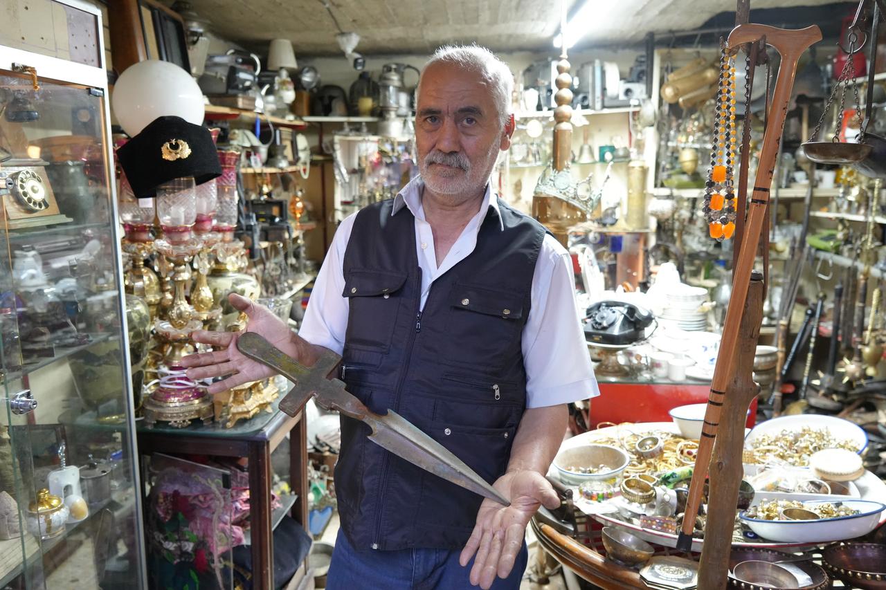 Hanifi Ozaslan displays an old blade among nostalgic objects, copperware and collectible items at his shop in Gaziantep, Türkiye. (IHA Photo)