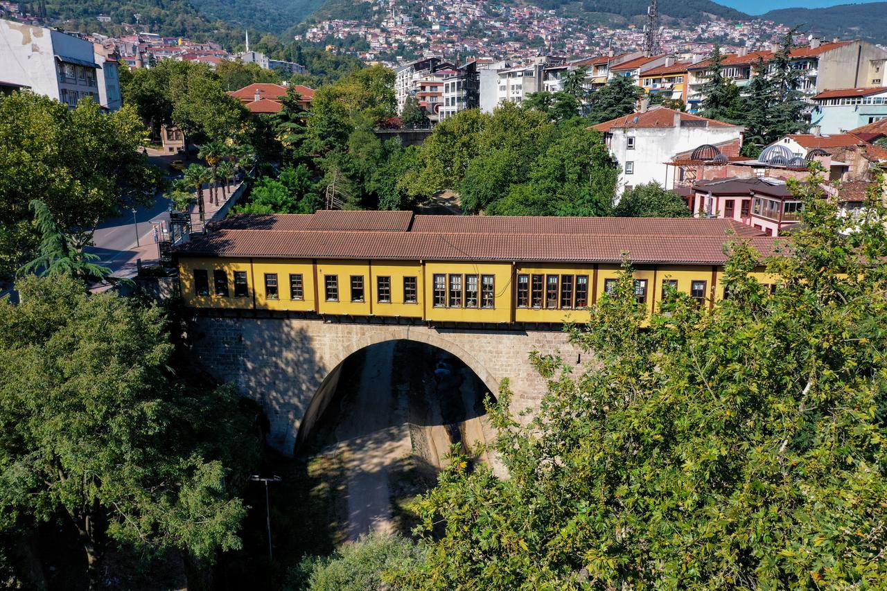 Bursa's historic Irgandi Bridge stands over a stream, surrounded by greenery and the city's hillside neighborhoods. (Photo via Ministry of Culture and Tourism)