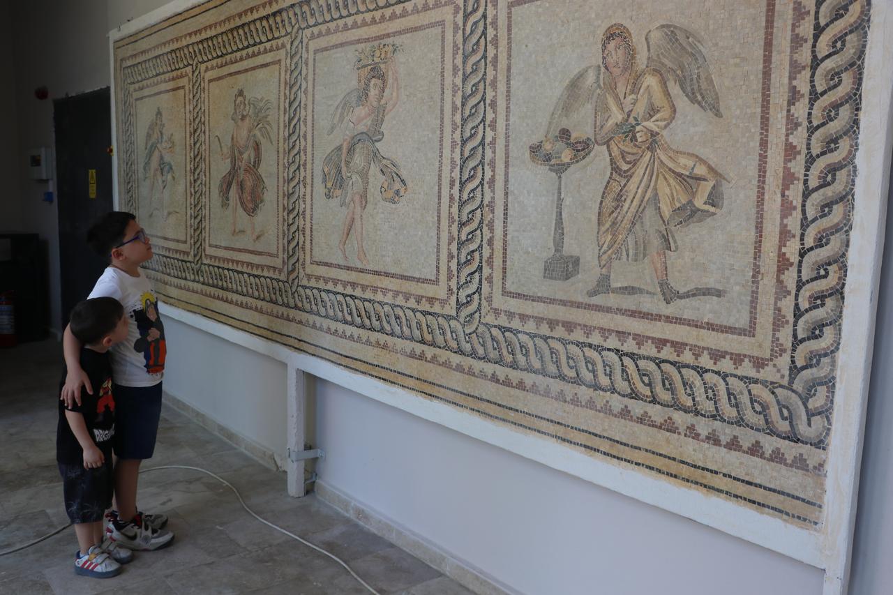 Children look at replica mosaic panels at an exhibition in Hatay that brings together works linked to Antakya’s dispersed cultural heritage. (AA Photo)