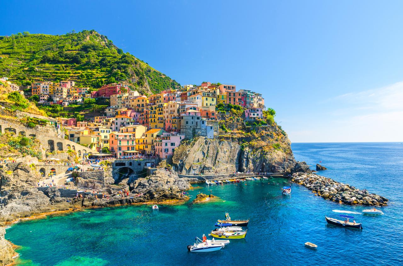 Colorful houses and boats are seen along the rocky coastline of Cinque Terre, one of Italy’s most popular tourist destinations. (Adobe Stock Photo)