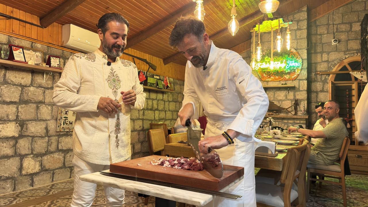 French Embassy chef Julien Moulieres cuts lamb with a traditional “zirh” knife as Biral Serttas looks on during an Adana kebab workshop in southern Türkiye. (AA Photo)