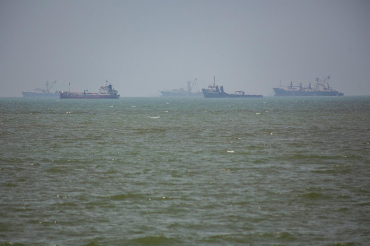 Large commercial vessels and a small boat navigate the waters off the southern port city of Bandar Abbas, Iran, on June 21, 2026. (AA Photo)