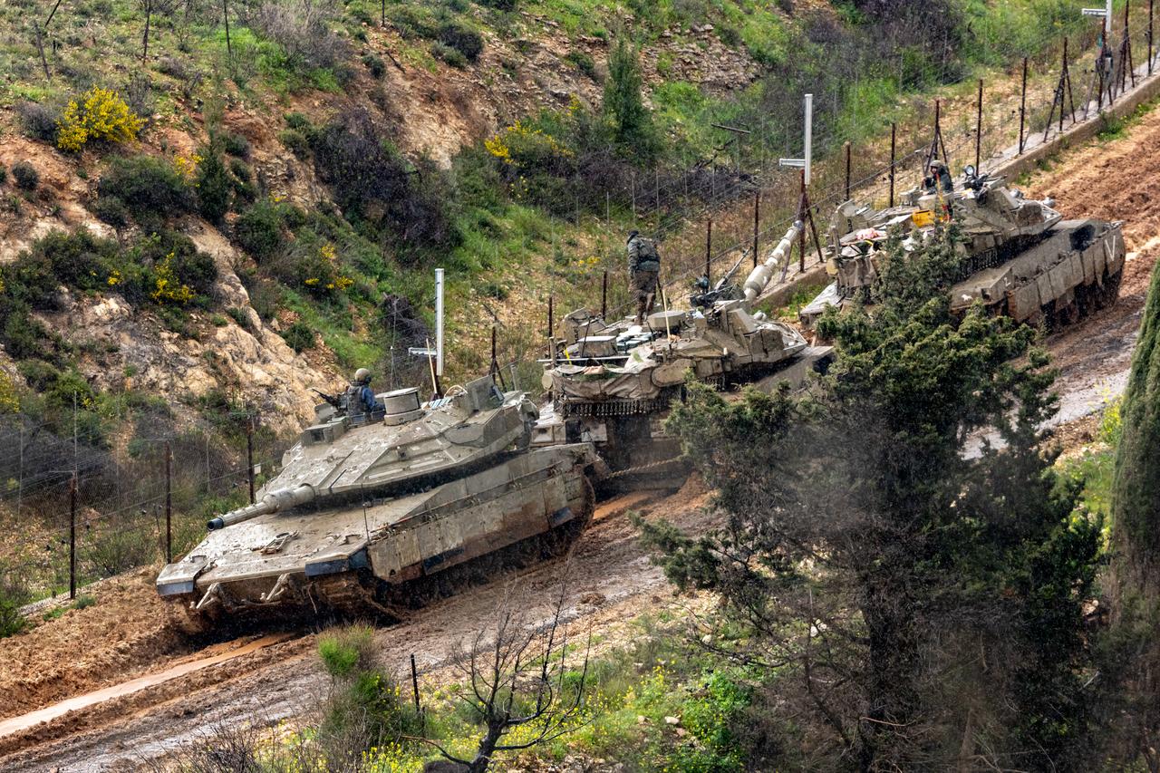 Israeli soldiers try to tow a tank stuck in the mud on the Israeli side of the border with Lebanon, in the Upper Galilee in northern Israel, March 21, 2026. (AFP Photo)