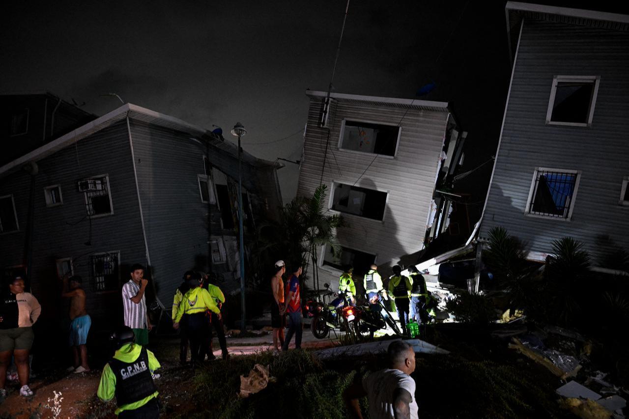 Residents and emergency workers stand near damaged buildings following an earthquake in Catia La Mar, La Guaira state, some 30kms north-west of Caracas, early on June 25, 2026. (AFP Photo)