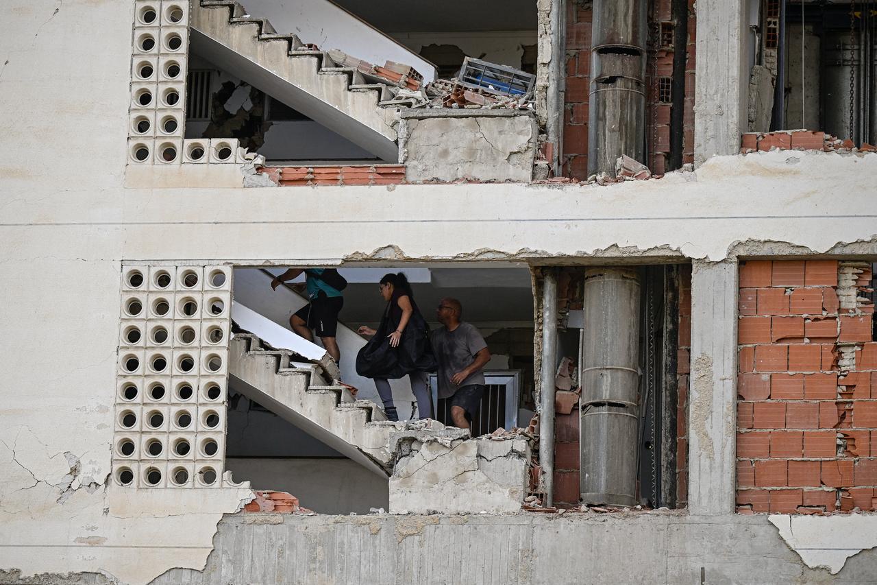 People walk inside a damaged apartment building following an earthquake in Catia La Mar, La Guaira state, some 30km north-west of Caracas, June 25, 2026. (AFP Photo)