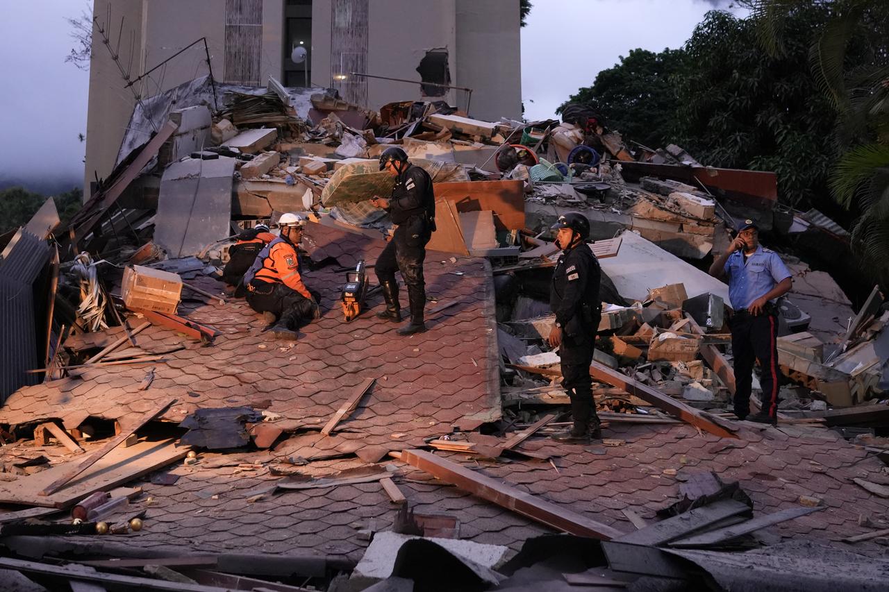 Rescue workers and municipal police officers work at the site of a collapsed building following an earthquake in Caracas on June 24, 2026. (AFP Photo)