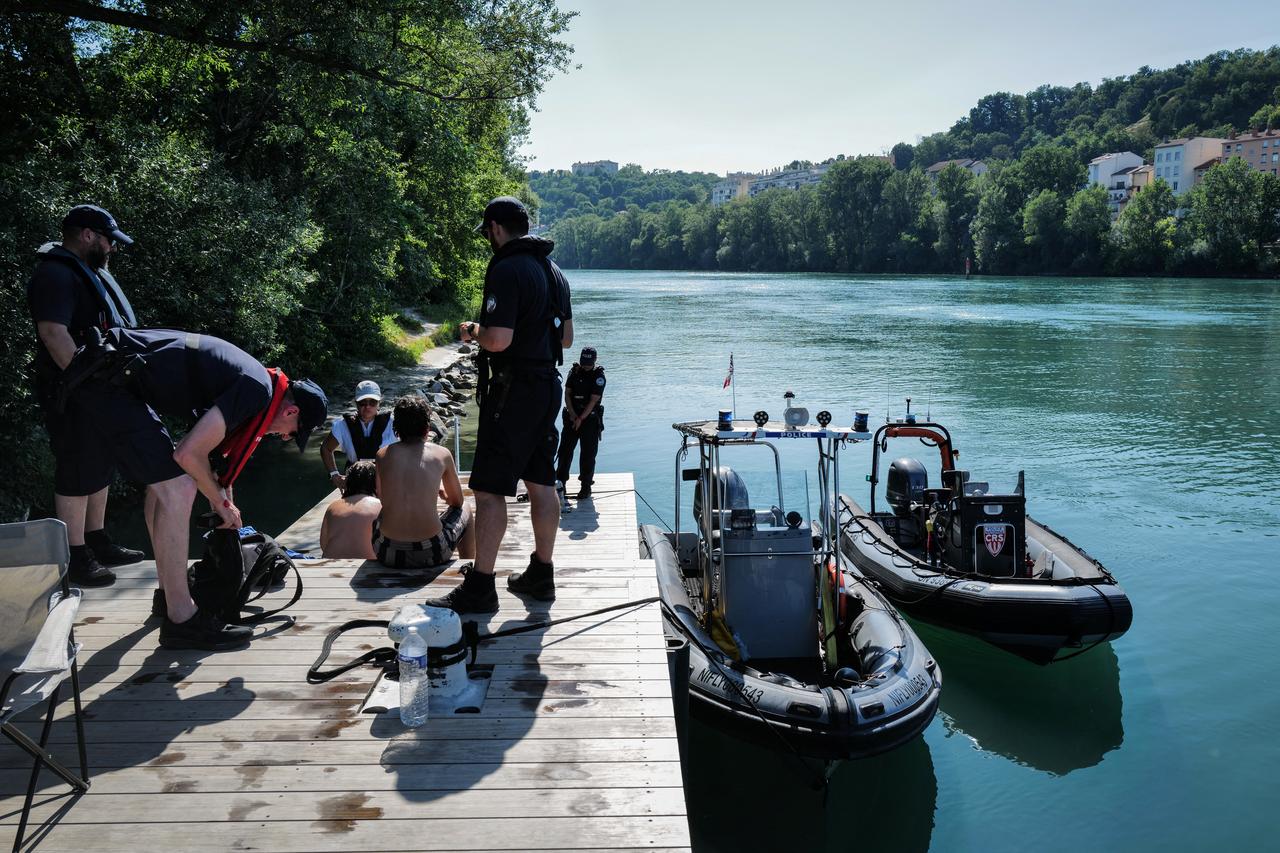 French National police and the river brigade control a group of teenagers who were jumping off the Passerelle de la Paix bridge into the Rhone river, in Lyon, southern France, June 25, 2026. (AFP Photo)