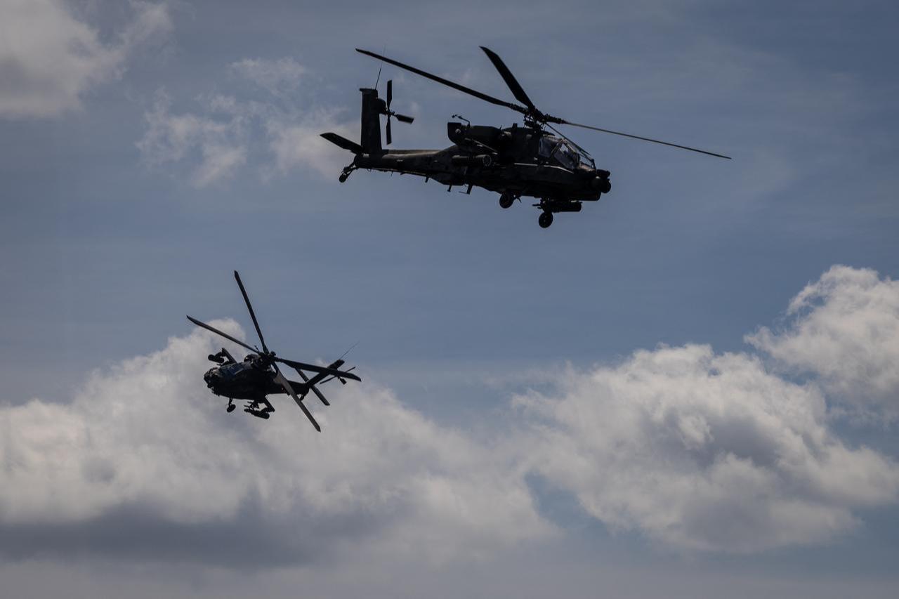 Two Polish Air Forces US-made AH-6h Apache helicopters participate in a lake crossing, as troops from Poland and Lithuania take part in the Amber Defender military exercise, north-eastern Poland, June 24, 2026. (AFP Photo)