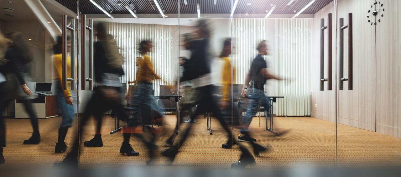 Business professionals walking through a office. (Adobe Stock Photo)