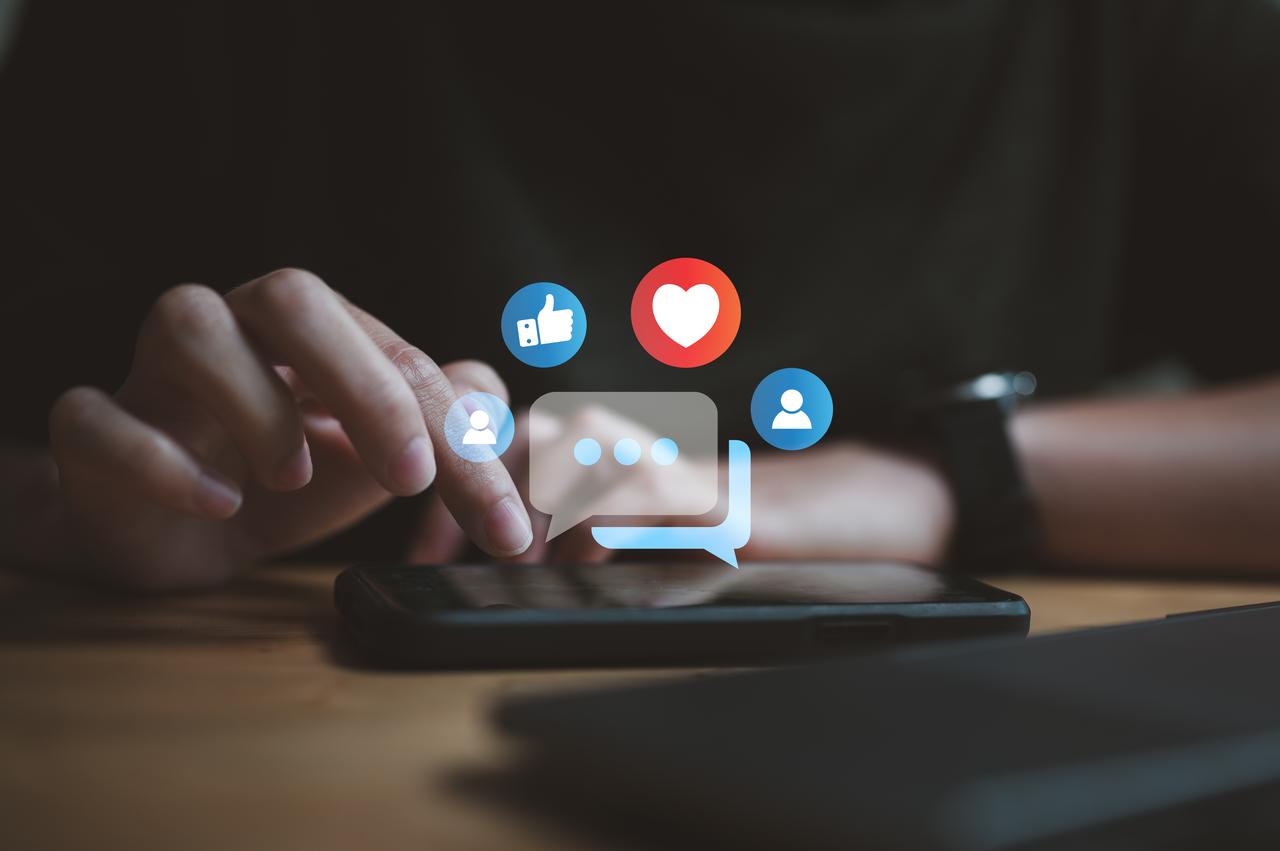 A person using social media applications on a smartphone. (Adobe Stock Photo)