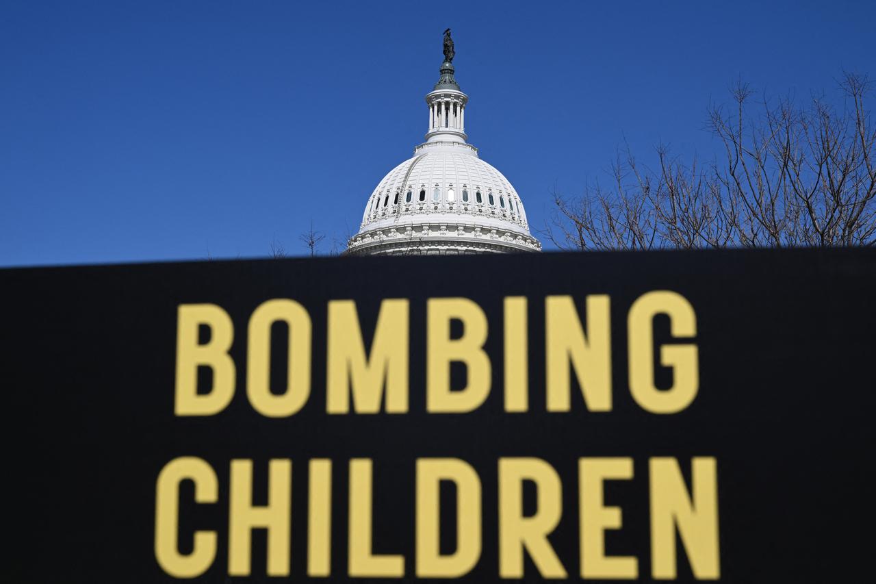 A memorial made up of signs, shoes and backpacks symbolizing those killed in the bombing of the Minab elementary school and other civilians killed in Iran sits outside the United States Capitol, March 18, 2026 in Washington, DC. (AFP Photo)