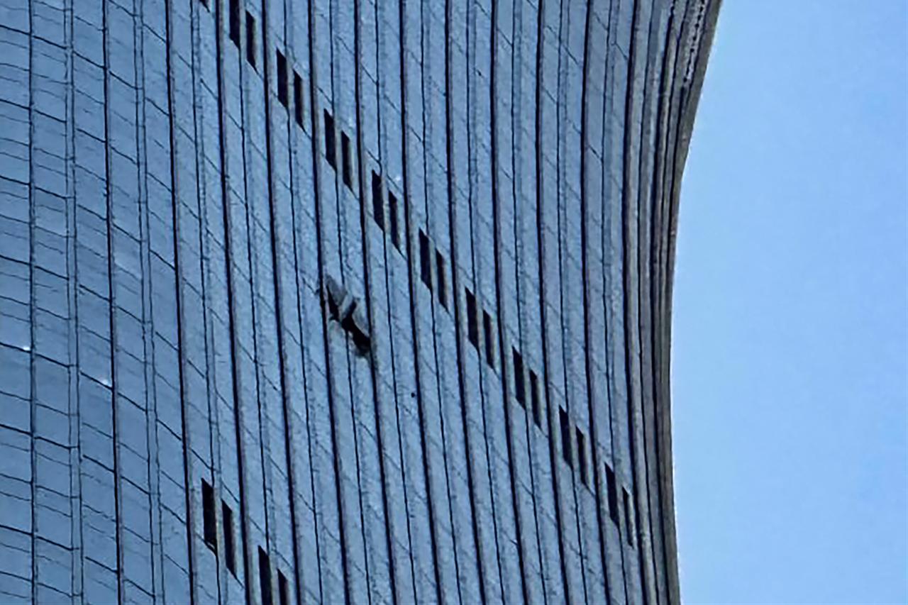 A hole is seen (R) on the side of the CITIC Tower in Beijing on June 26, 2026, after an eyewitness reported plane debris at the base of Beijing's tallest building. (AFP Photo)