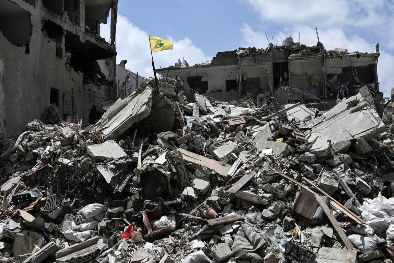 A yellow flag belonging to the Iran-backed Shia Muslim party Hezbollah flutters on top of the rubble of a building in the southern Lebanese coastal city of Tyre, June 23, 2026. (AFP Photo)