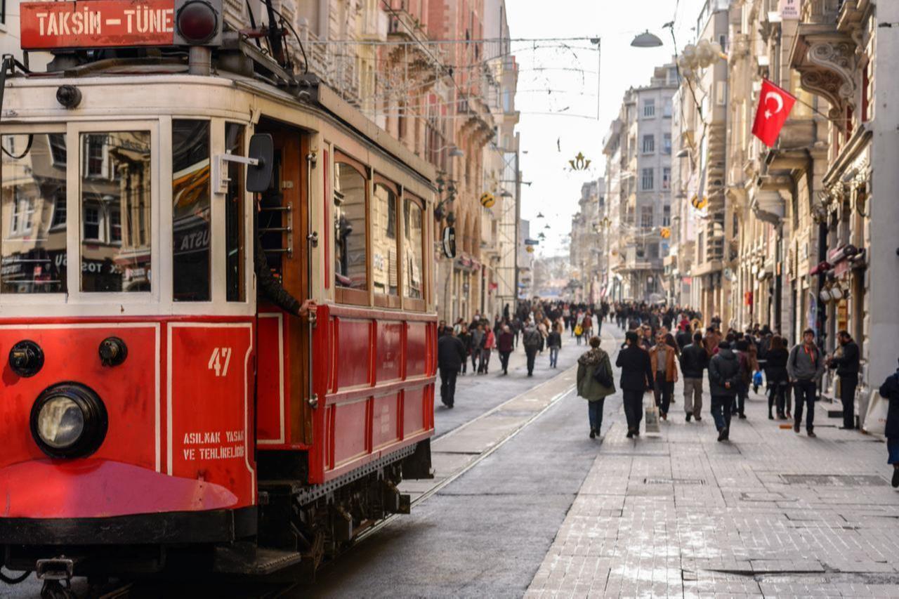 A historic red tram makes its way down bustling Istiklal Avenue in Istanbul, Türkiye. (Adobe Stock Photo)