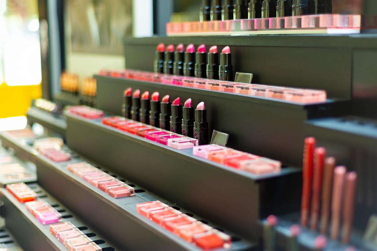 Lipsticks and makeup products are displayed at a cosmetics store. (Adobe Stock Photo)