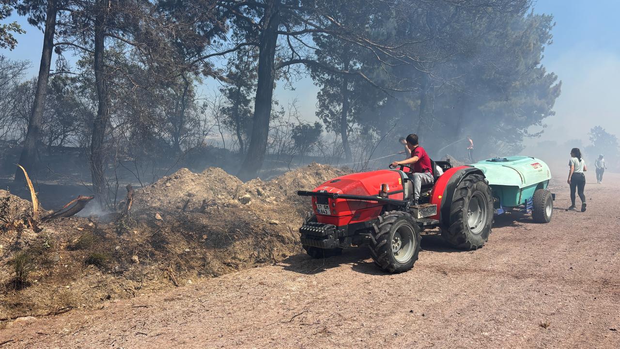 Local residents use a tractor and water tanker as smoke fills the area during a fire in Canakkale, northwestern Türkiye, June 29, 2026. (IHA Photo)