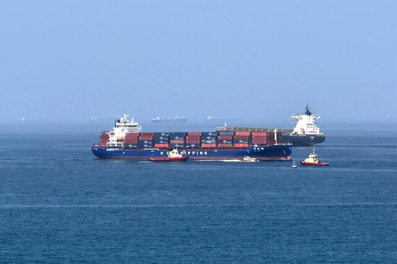 A cargo ship is pictured off coast of the Khor Fakkan Container Terminal, the only natural deep-sea port in the region and one of the major container ports in Sharjah Emirate, along the Gulf of Oman, June 28, 2026. (AFP Photo)