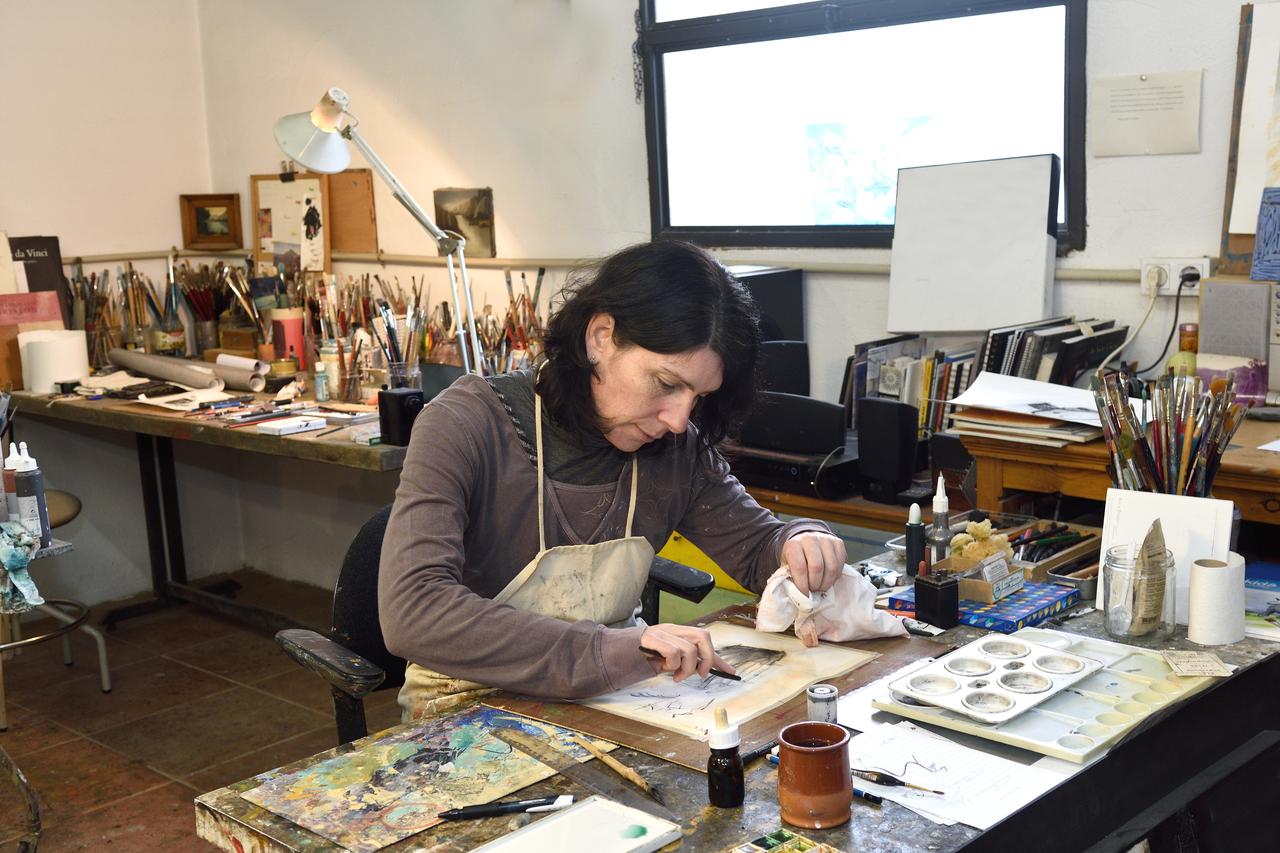 An artist works on a drawing in a studio. (Adobe Stock Photo)