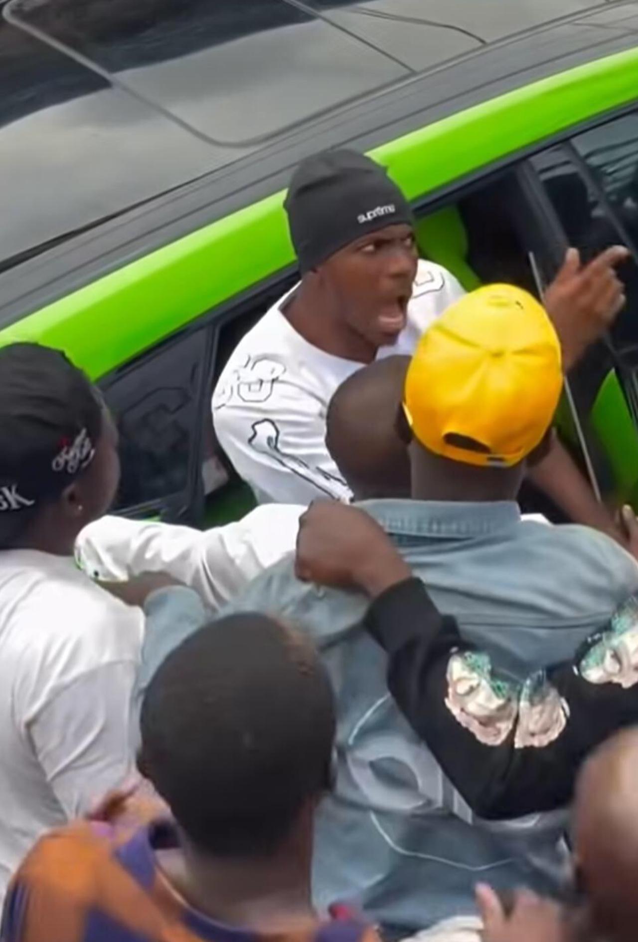 Osimhen reacts from inside a car as a group gathers around him in a screenshot from a video shared on X. (Photo via X)
