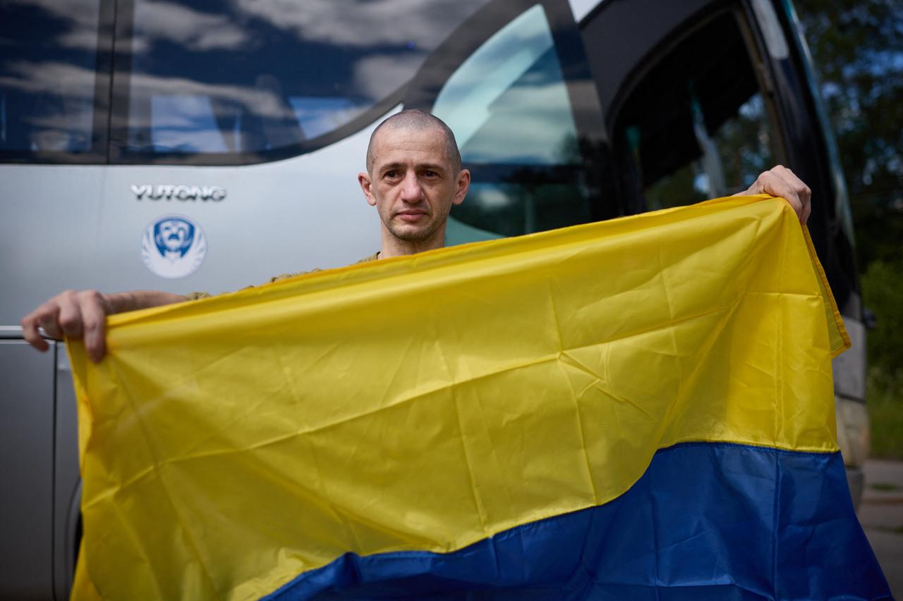 In this handout photograph taken on June 26, 2026, a former Ukrainian prisoner of war holds a Ukrainian national flag. (Photo by Handout/Coordination Headquarters for the Treatment of Prisoners of War/AFP)