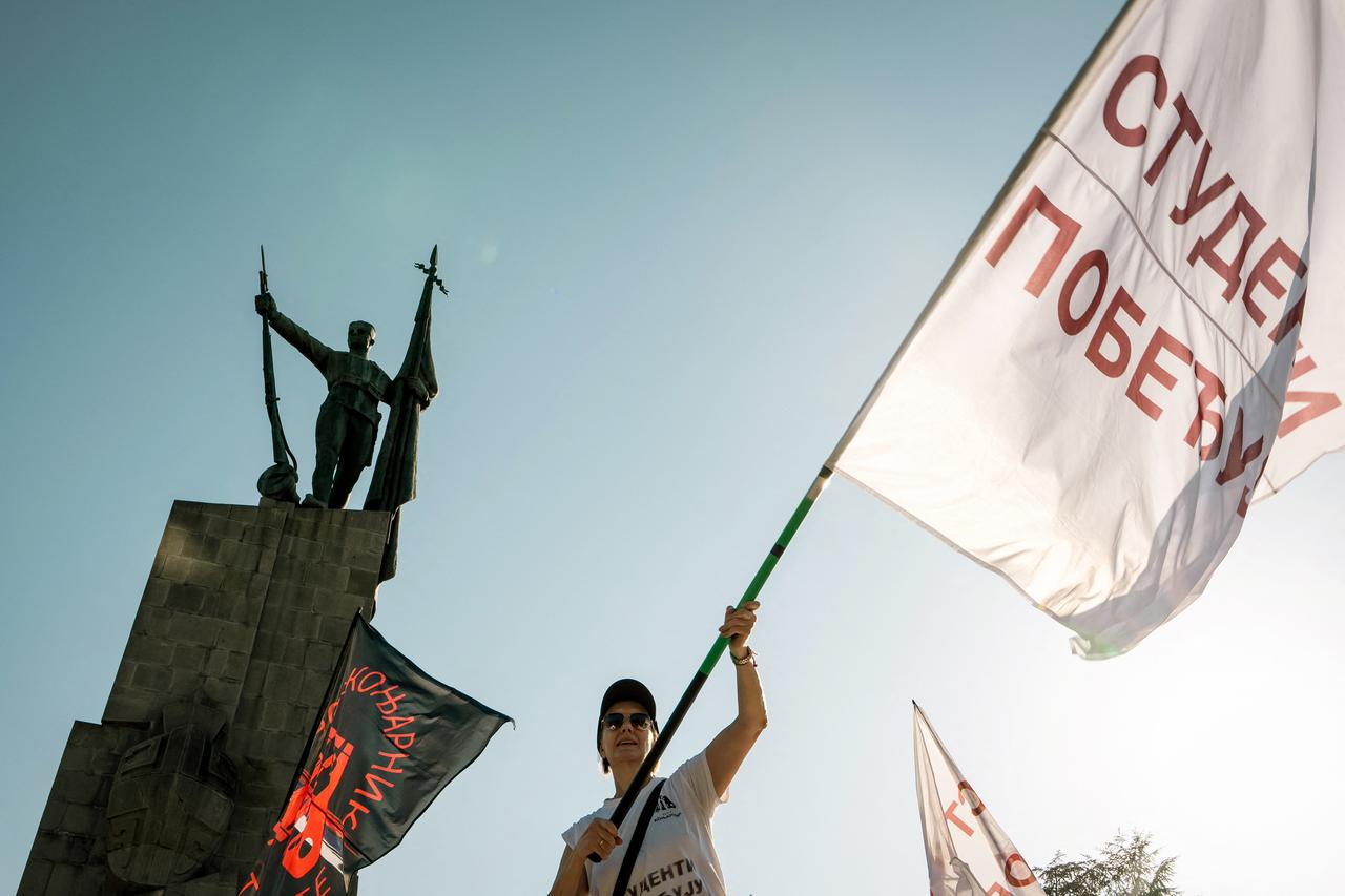 A protestor waves a giant flag while taking part in a gathering in Kraljevo, central Serbia, on June 28, 2026, for a rally called by students, a day after Serbia's President Aleksandar Vucic said he would step down within "weeks" following more than a year of student-led protests. (AFP Photo)