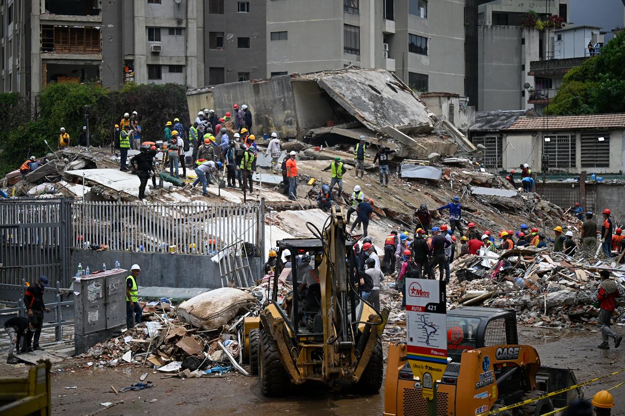 Workers remove debris from a collapsed building in the San Bernardino neighborhood of Caracas on June 28, 2026, following earthquakes. (AFP Photo)