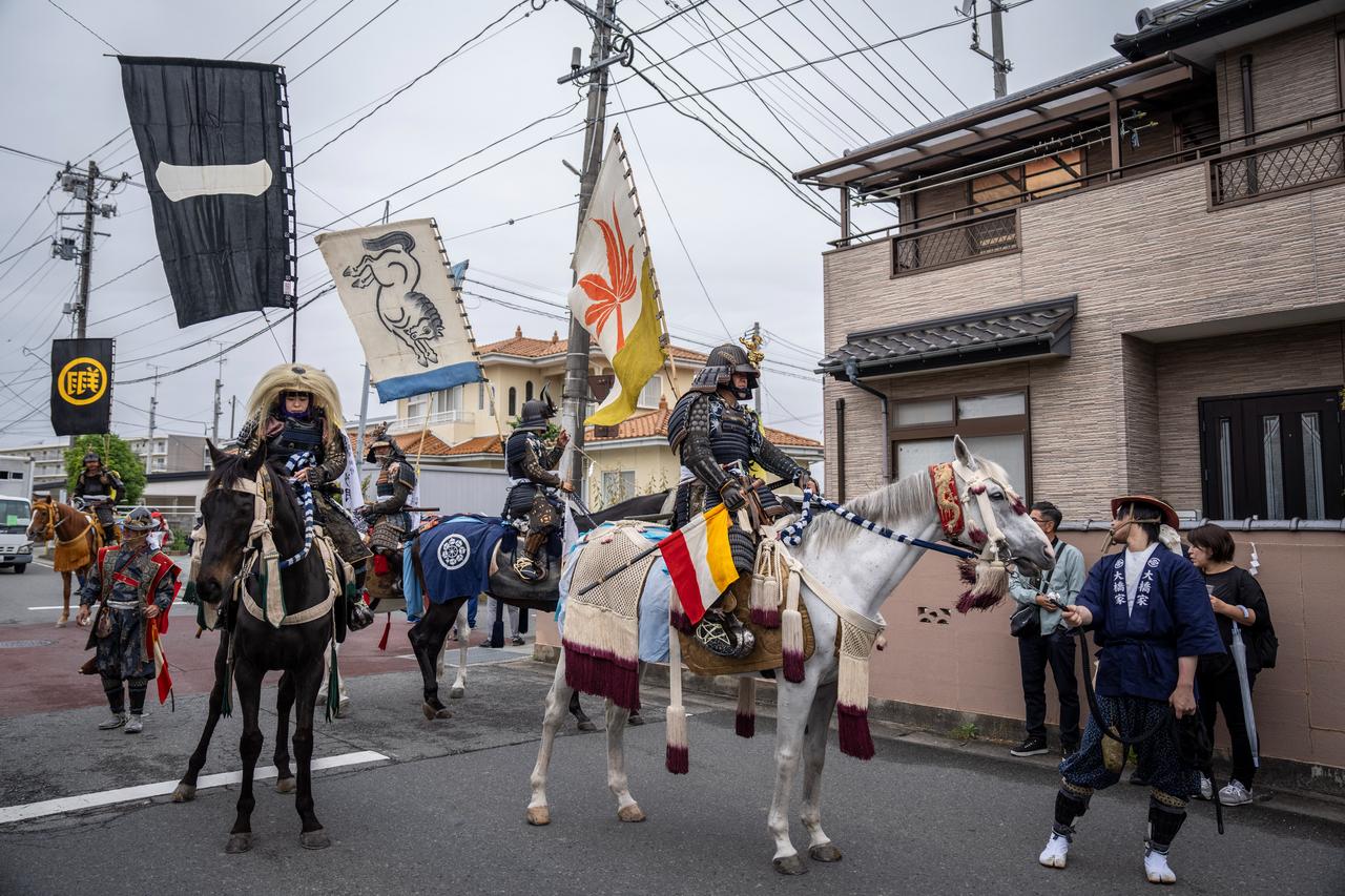 Horsemen clad in samurai armor riding through a residential neighbourhood during the Soma Nomaoi festival in Minamisoma, Fukushima prefecture.(AFP Photo)