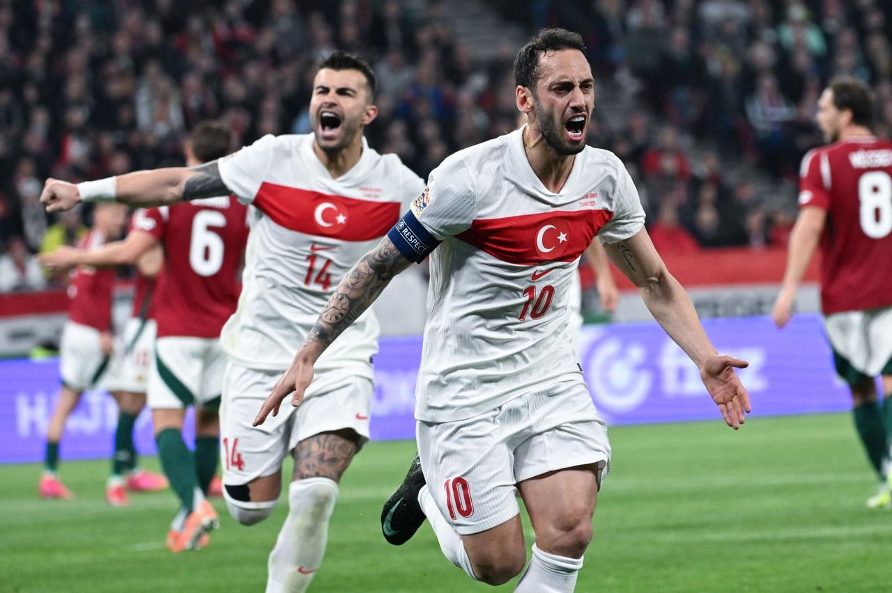 Türkiye's Hakan Calhanoglu (R) celebrates with teammate Abdulkerim Bardakci after he scored a goal during the UEFA Nations League Division A playoff second leg match against Hungary at Puskas Arena, Budapest, Hungary, March 23, 2025. (EPA Photo)