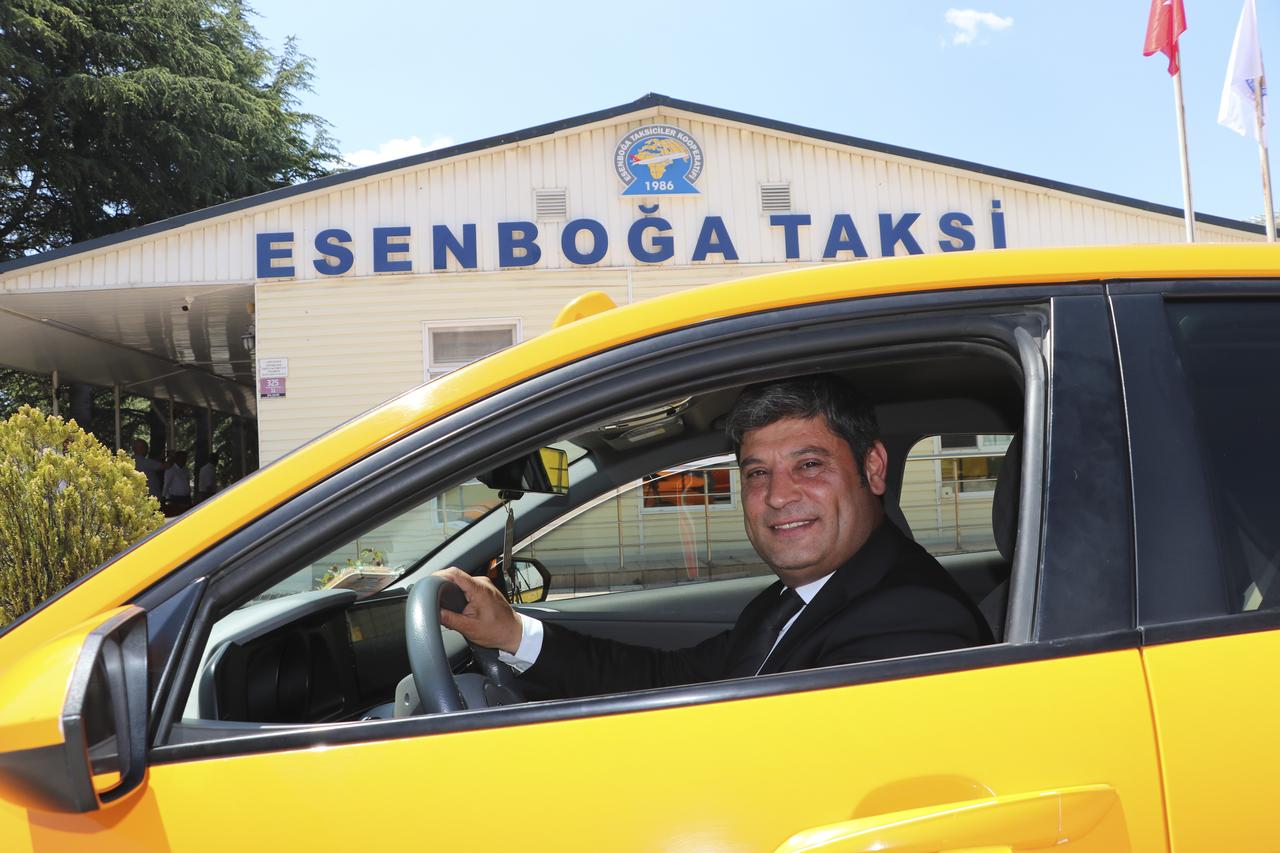 A taxi driver poses inside his vehicle in front of the Esenboga taxi stand ahead of the NATO Summit in Ankara, Türkiye. (AA Photo)