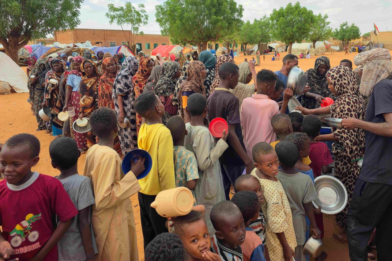 Women and children queue to receive free food being distributed in al-Mohayra camp for displaced people, near the city of El-Obeid in the southern Kordofan region, on June 29, 2026. (AFP Photo)