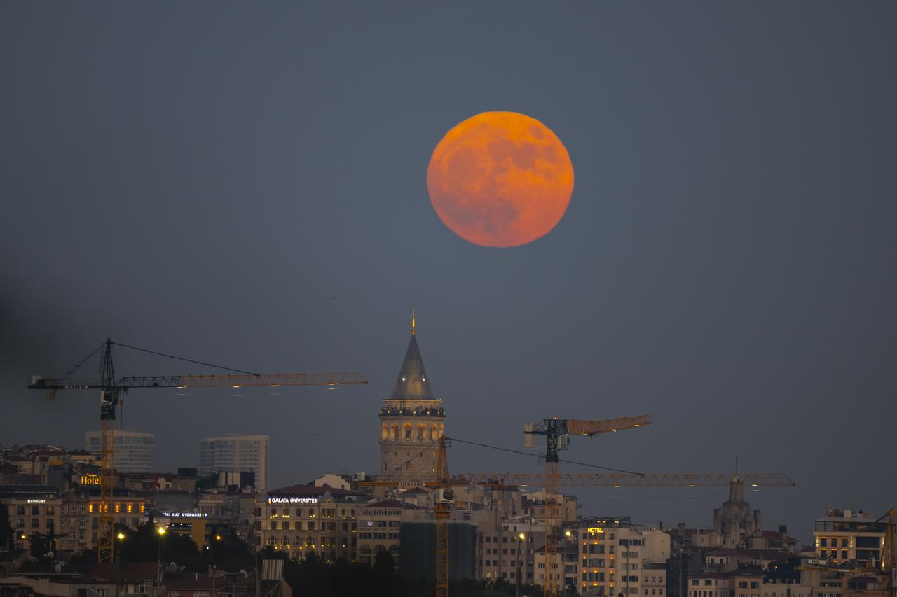 A full moon rises over Galata Tower and the Istanbul skyline in Türkiye, June 29, 2026. (AA Photo)