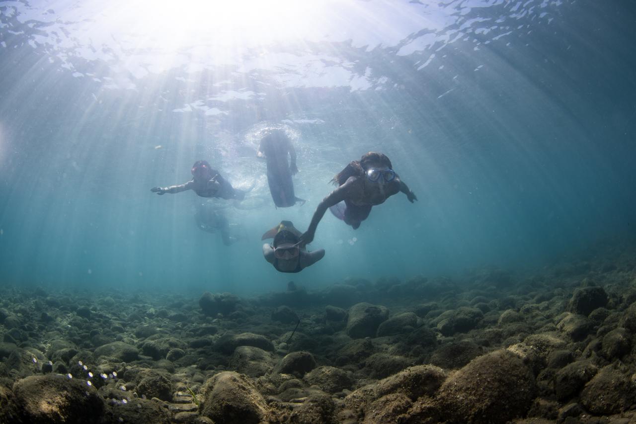 Middle school students who successfully completed an environmental training program and participated in localized waste-collection efforts receive a scuba diving experience as their end-of-term report card reward in the Karaburun district of Izmir, Türkiye, June 21, 2026. (AA Photo)
