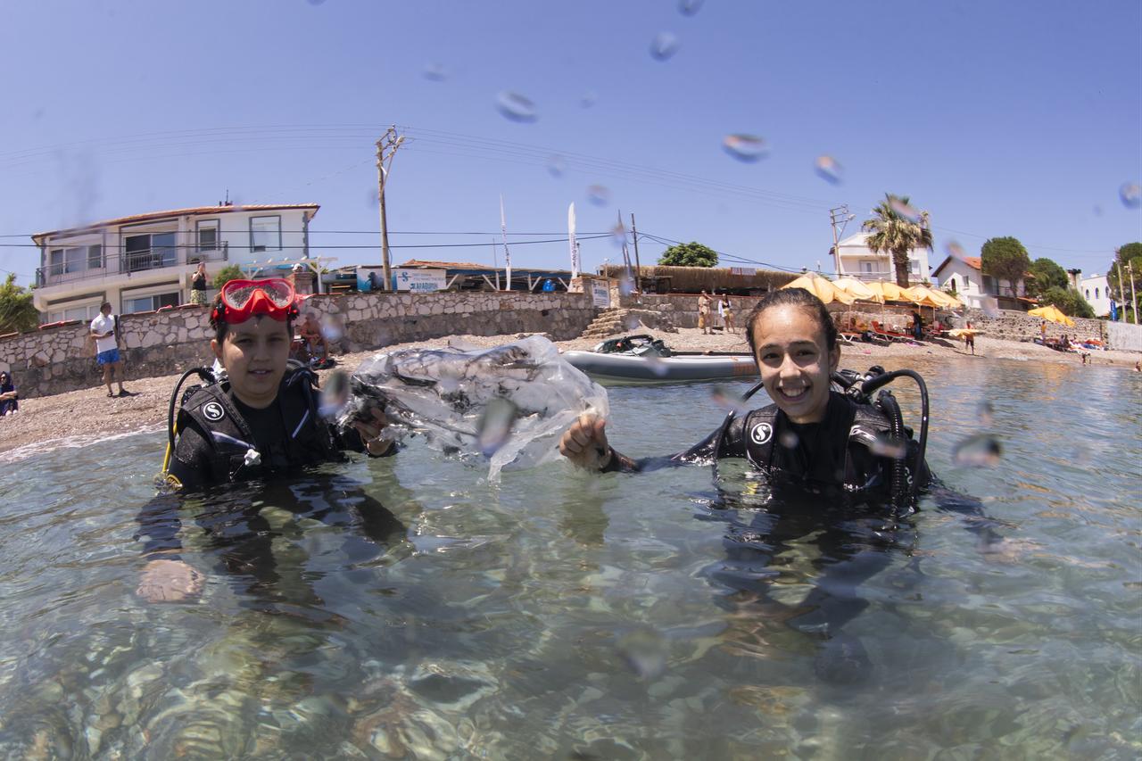 Middle school students who successfully completed an environmental training program and participated in localized waste-collection efforts receive a scuba diving experience as their end-of-term report card reward in the Karaburun district of Izmir, Türkiye, June 21, 2026. (AA Photo)