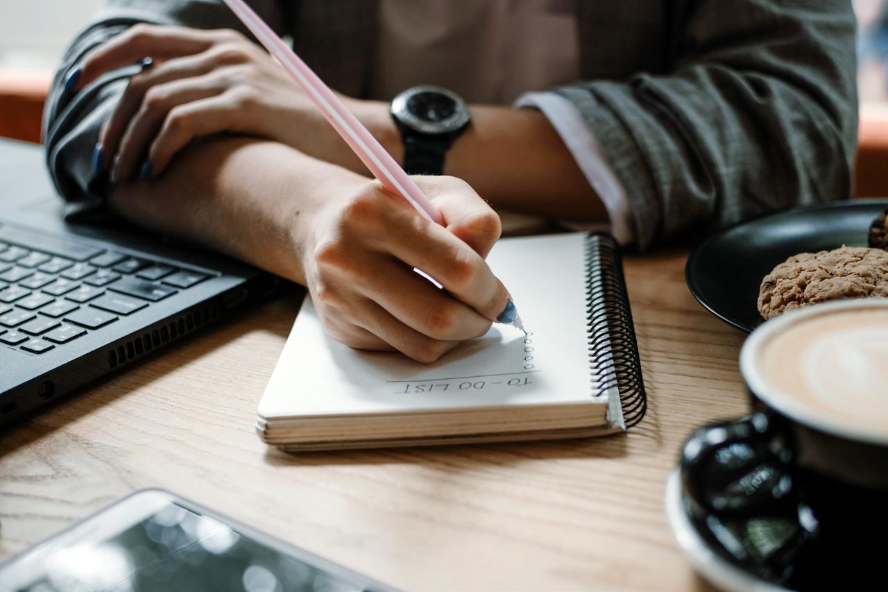 Close up of female hand writing check to-do list in notebook. (Photo via Adobe Stock)