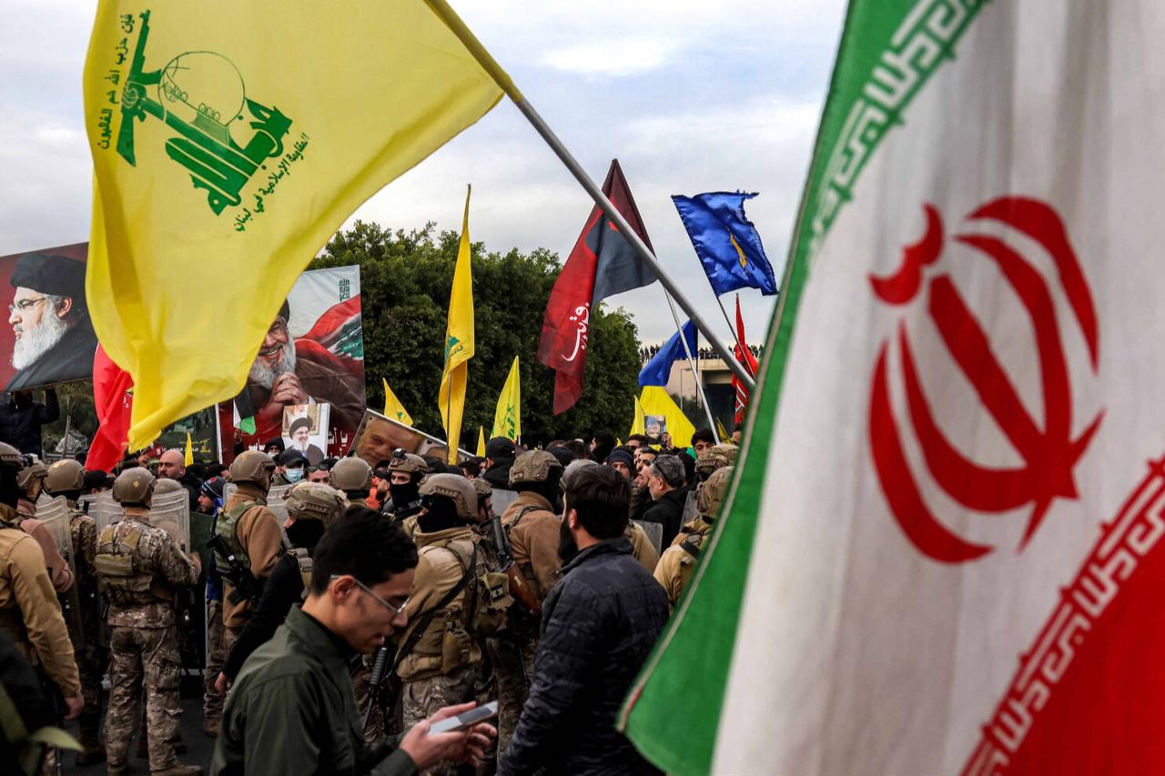 Flags of Iran and Hezbollah are carried by protesters gathering before Lebanese soldiers during a rally in Beirut, Feb. 15, 2025. (AFP Photo)