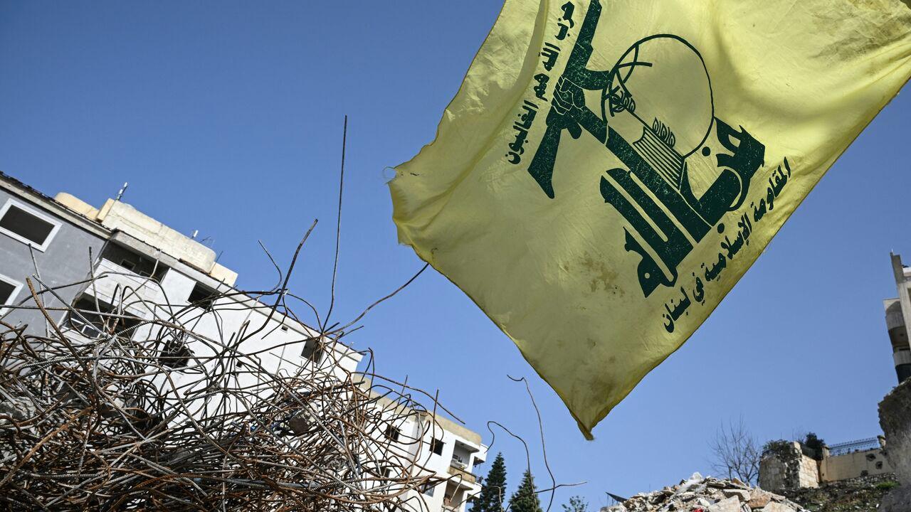 A flag of the Lebanese Shiite movement Hezbollah flutters above the rubble of a building that was hit in January by an Israeli strike in the southern Lebanese village of Qannarit, on Feb. 16, 2026. (AFP Photo)