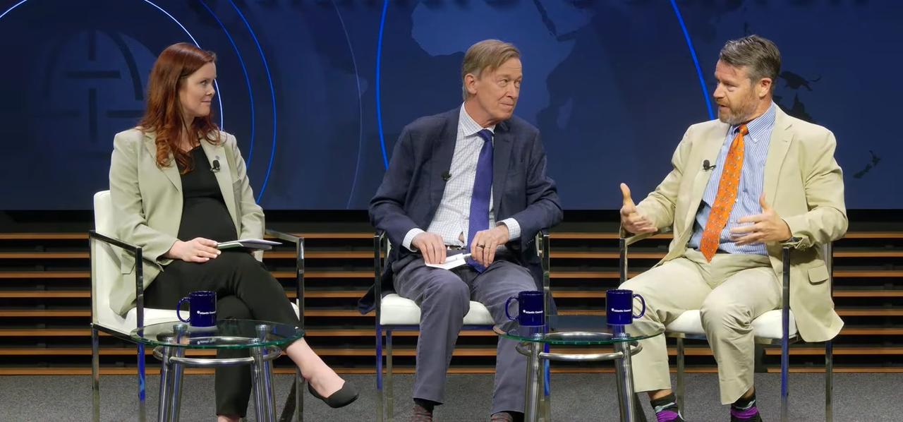 The image captures US Senators Todd Young and John Hickenlooper alongside moderator Tess deBlanc-Knowles during an Atlantic Council event addressing the future of artificial intelligence governance. (via AC TV)