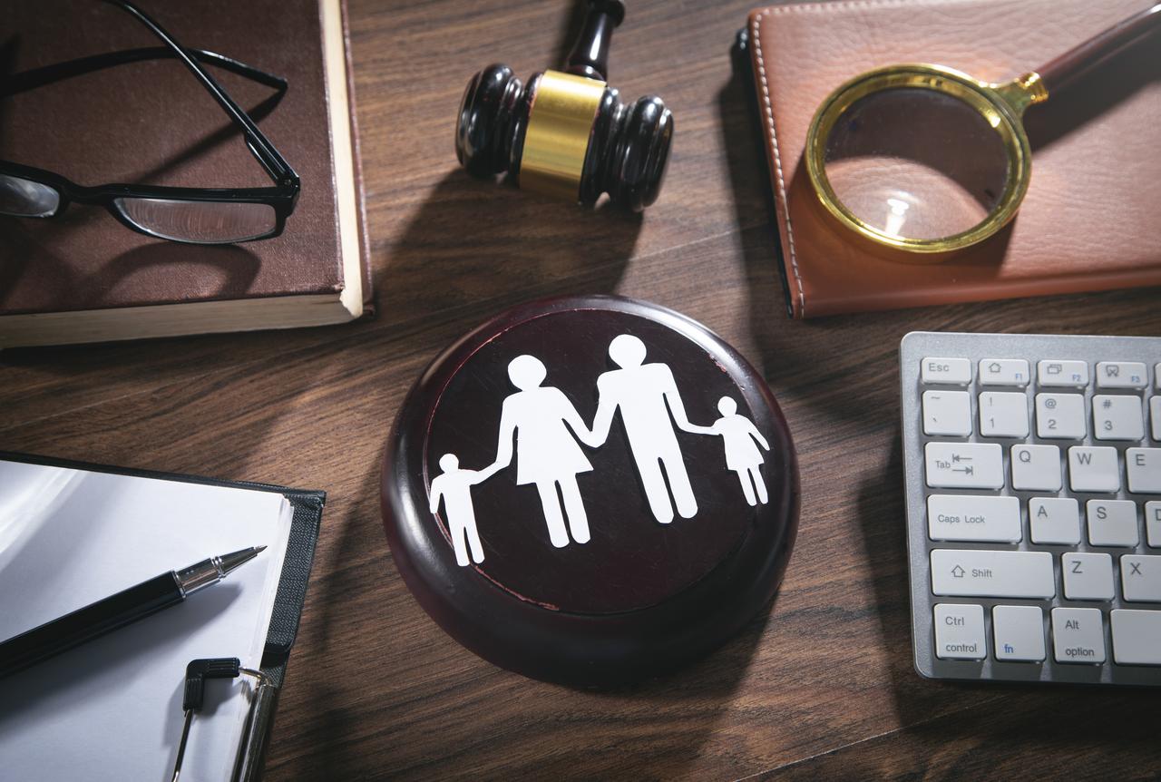 A gavel and a family symbol are seen on a legal desk, representing divorce and alimony cases. (Adobe Stock Photo)