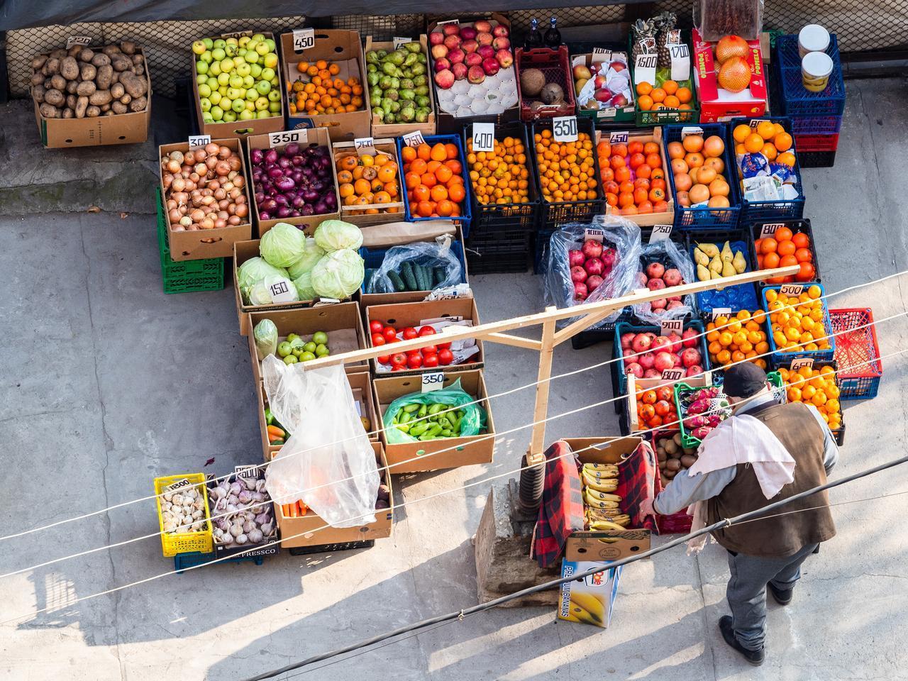 Aerial view of a local fresh vegetables and fruits stall with a seller in the city courtyard on a winter day, Yerevan, Armenia, December 7, 2024. (Adobe Stock Photo)