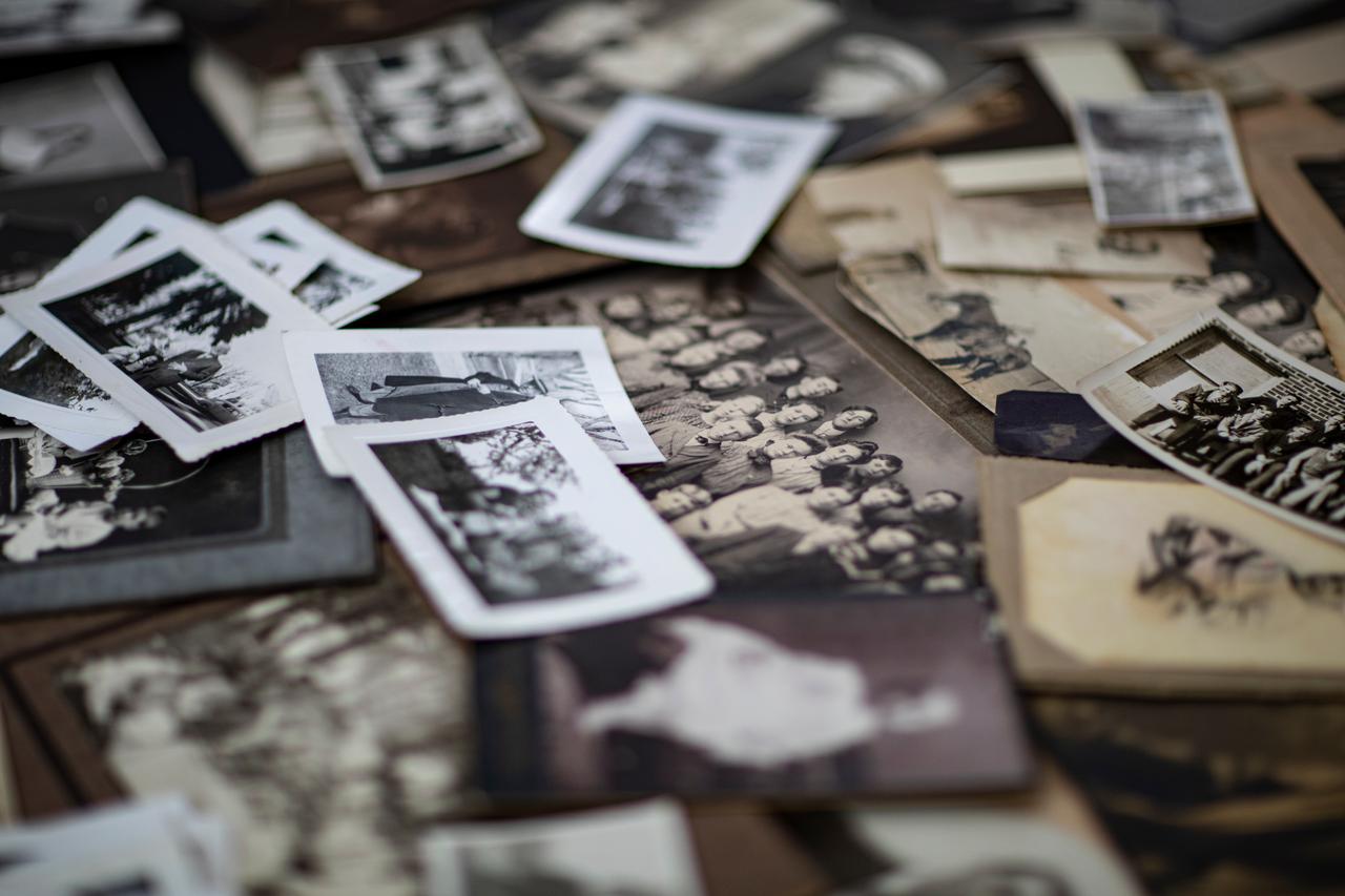 Old family photographs are displayed on a table (Adobe Stock Photo)