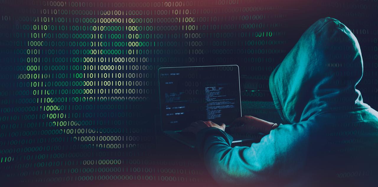 Hooded hacker manipulates software. (Photo vie Adobe Stock)