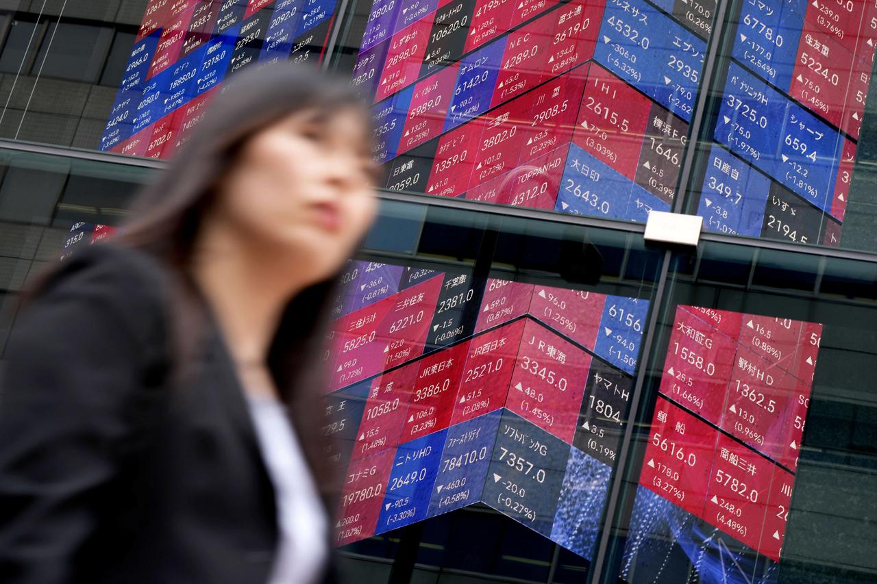 A woman walks past an electronic quotation board displaying the Nikkei 225 stock prices on the Tokyo Stock Exchange along a street in Tokyo, June 5, 2026. (AFP Photo)