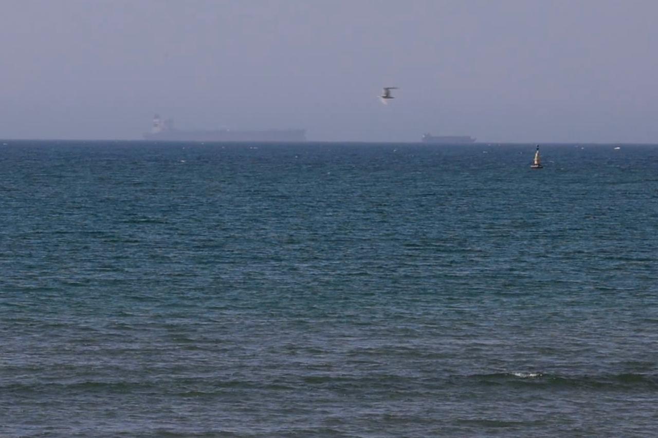 A screenshot from a video shows commercial vessels waiting in the Gulf of Oman after applying for transit permits to pass through the Strait of Hormuz, on June 4, 2026. (AA Photo)