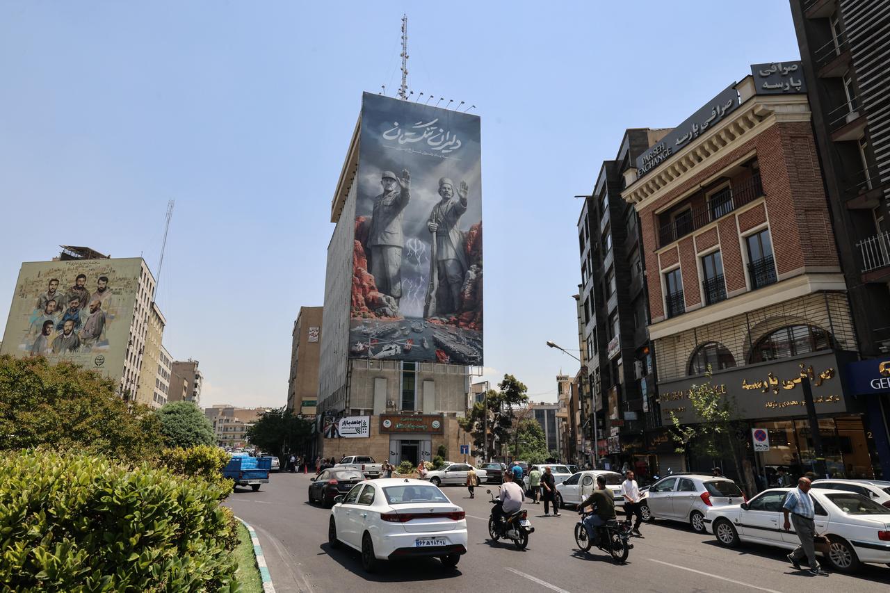 Commuters drive past a large banner depicting the closure of the Strait of Hormuz in Tehran on June 3, 2026. (AFP Photo)