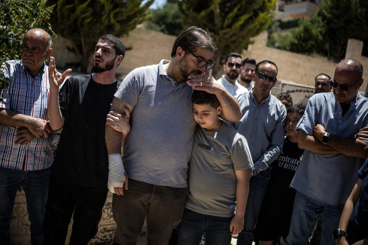 Fahd Abou Haikal, a Palestinian man, comforts his elder son Kinan Abou Haikal after burying his seven-month-old baby, Sam Fahd Abou Haikal, in Hebron, in the occupied West Bank, June 6, 2026. (AFP Photo)