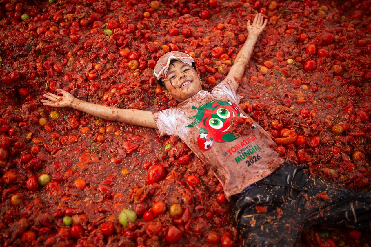 Child lying on crushed tomatoes during the 16th edition of the Great Colombian Tomatina in Sutamarchan, Colombia, on June 07, 2026. (AA Photo)